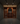 Wine cellar with wooden rack filled with wine bottles against stone walls.