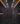 Large wine cellar with wooden shelves filled with wine bottles, dimly lit.