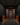 Dark wine cellar with wooden wine rack filled with bottles.