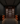 Dark wine cellar with wooden wine rack filled with bottles.